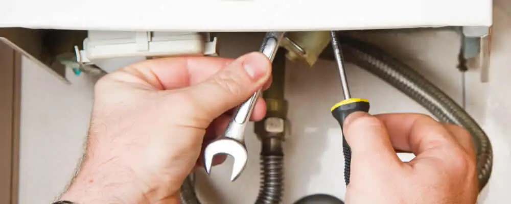 Boiler repair technician tightening pipe fittings and connections in Santa Rosa, CA