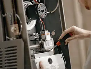 Furnace repair technician inspecting internal components and wiring in Santa Rosa, CA