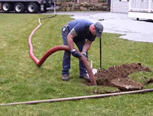 Septic pumping technician servicing a residential septic tank with a vacuum hose in Santa Rosa, CA