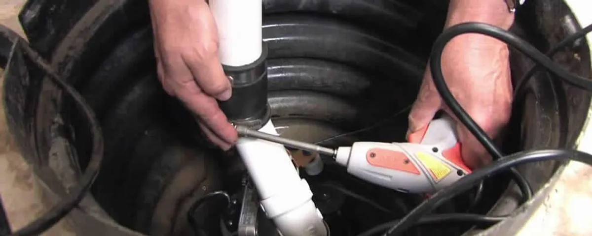 Sump pump installation technician connecting PVC discharge piping in Santa Rosa, CA