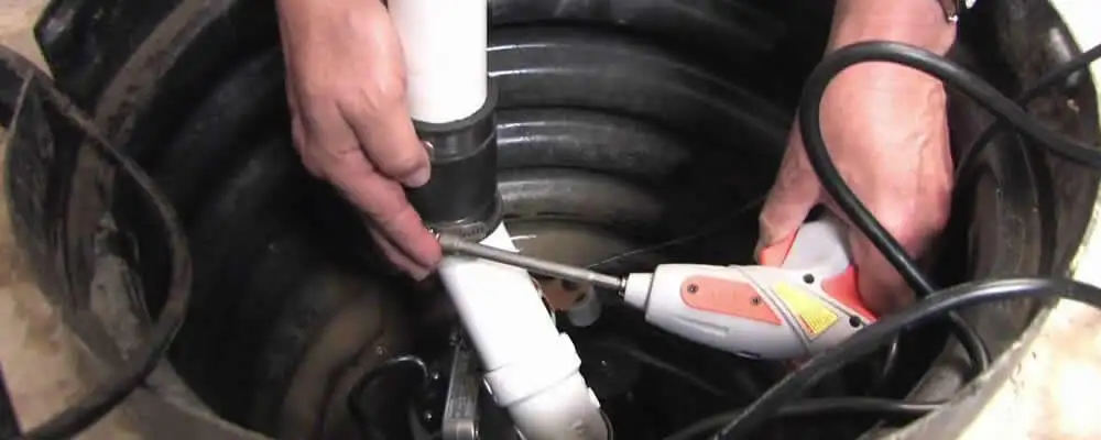 Sump pump installation technician connecting PVC discharge piping in Santa Rosa, CA
